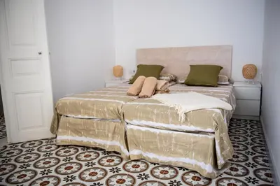 a bedroom with a large bed with green pillows at Hauzify I Apartament Can Missé in Calella