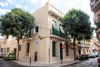 a building on the side of a street with trees at Hauzify I Apartament Can Missé in Calella
