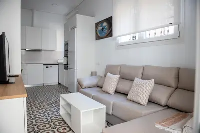 a living room with a couch and a kitchen at Hauzify I Apartament Can Missé in Calella