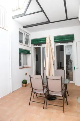 a patio with two chairs and a table and a umbrella at Hauzify I Apartament Can Missé in Calella