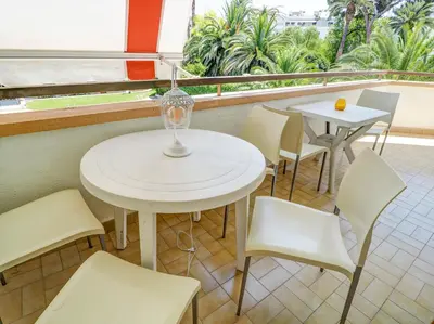 a white table and chairs in a room with a window at Clarimar Beach Apartment by Hello Homes Sitges in Sitges
