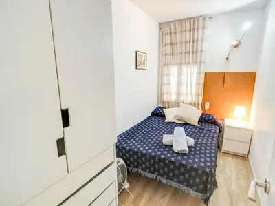 a small bedroom with a blue bed in a room at Clarimar Beach Apartment by Hello Homes Sitges in Sitges