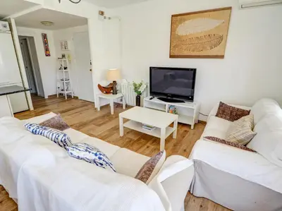 a living room with two white couches and a flat screen tv at Clarimar Beach Apartment by Hello Homes Sitges in Sitges