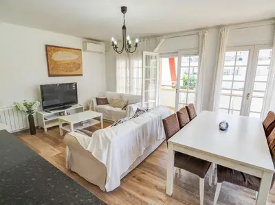 a living room with a couch and a table at Clarimar Beach Apartment by Hello Homes Sitges in Sitges