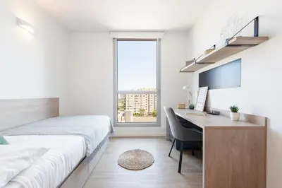 a bedroom with a bed and a desk with a computer at Micampus Barcelona Student Residence in Barcelona