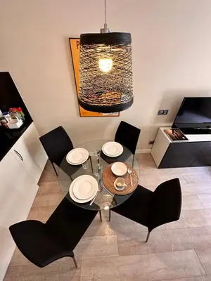 a dining room with a glass table and black chairs at Gracia Barcelona Apartment in Barcelona