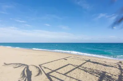 a shadow of a couple on the beach at HomeHolidaysRentals Milos - Costa Barcelona in Pineda de Mar