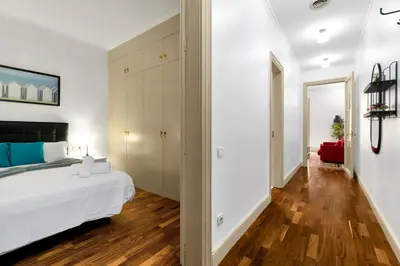 a bedroom with a white bed and a hard wood floor at Tendency Apartments 6 in Barcelona