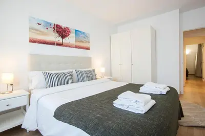 a white bedroom with a large bed with towels on it at Tendency Apartments 6 in Barcelona
