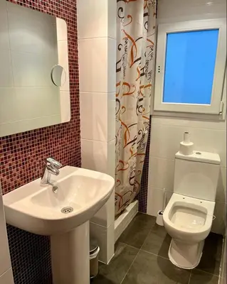 a bathroom with a sink and a toilet and a window at Large Apartment near FIRA and City Center in Hospitalet de Llobregat