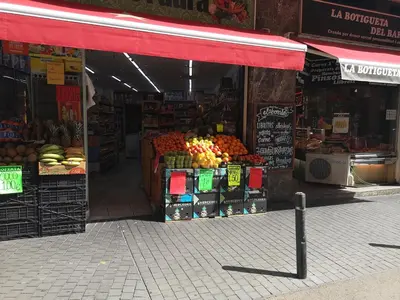 a store with fruits and vegetables on a street at ApartEasy - Atic Sants in Barcelona