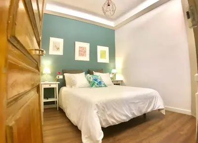 a bedroom with a bed and a blue wall at LEPANTO APARTMENTS 150m FROM SAGRADA FAMILIA in Barcelona