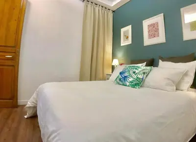 a bedroom with a large white bed with green walls at LEPANTO APARTMENTS 150m FROM SAGRADA FAMILIA in Barcelona