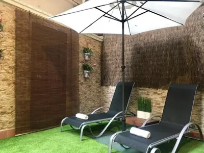 two chairs and an umbrella in a room with grass at Front Arc in Barcelona