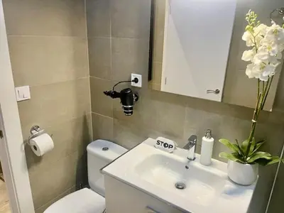 a bathroom with a sink and a toilet and a mirror at Front Arc in Barcelona