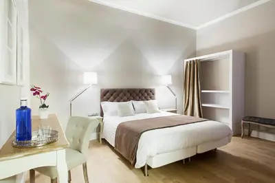 a white bedroom with a bed and a table at BacHome Gallery B&B in Barcelona