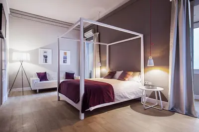 a bedroom with a canopy bed and a couch at BacHome Gallery B&B in Barcelona