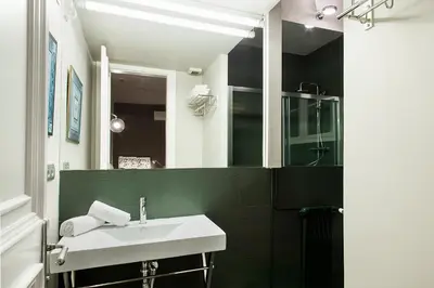 a bathroom with a sink and a glass shower at BacHome Gallery B&B in Barcelona