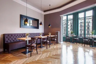 a restaurant with tables and chairs and large windows at BacHome Gallery B&B in Barcelona