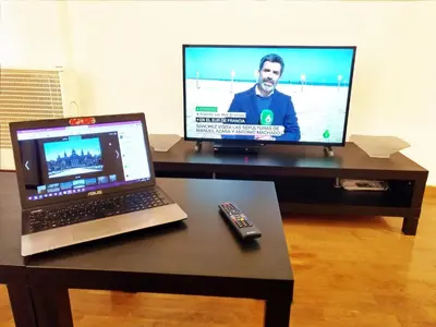 a desk with a laptop and a television on it at La Fira in Barcelona