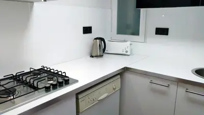a white kitchen with a stove and a sink at La Fira in Barcelona