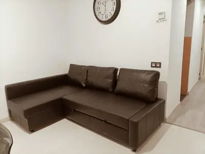 a brown leather couch in a living room with a clock at Molino Fresh in Barcelona