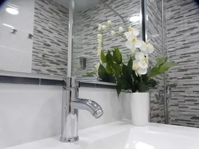a bathroom sink with a vase of flowers on it at Ca la Carmeta in Cunit