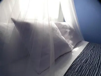 a bedroom with a bed and a window with sunlight at Ca la Carmeta in Cunit