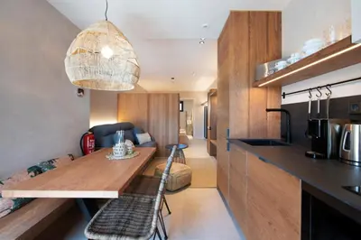 a kitchen and living room with a dining table in a room at Apartamentos Balisse in Castelldefels