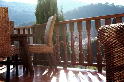 a balcony with two chairs and a view of the mountains at VACACIONES EN MARESME CASA PARA 7 PERSONAS in Sant Iscle de Vallalta