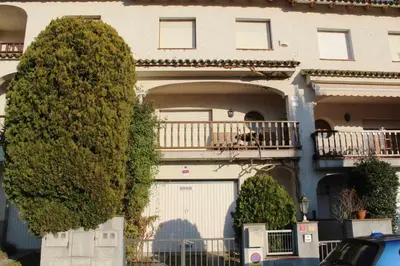 a large house with a garage and a balcony at VACACIONES EN MARESME CASA PARA 7 PERSONAS in Sant Iscle de Vallalta