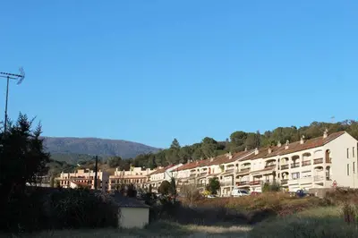 a group of buildings on a hill with mountains in the background at VACACIONES EN MARESME CASA PARA 7 PERSONAS in Sant Iscle de Vallalta