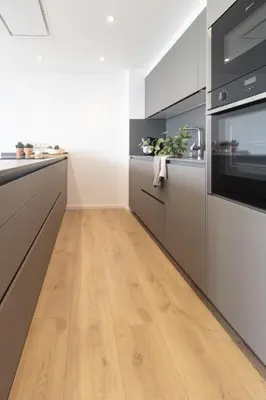 a kitchen with wooden floors and stainless steel appliances at Vivalidays Apartour - Calella in Calella