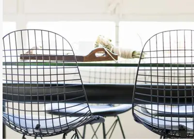 two chairs in front of a table with a surfboard at Glocal Apartments Barcelona in Barcelona