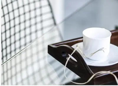 a coffee cup sitting on a plate on a table at Glocal Apartments Barcelona in Barcelona