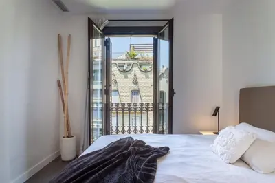 a white bedroom with a large bed and a window at The Collection Barcelona - 3-bedroom penthouse with terrace in Eixample in Barcelona