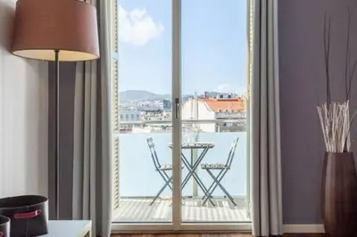 a room with a large window with a table and a balcony at The Collection Barcelona - Wonderful 2-bd apart with balcony Plaza Cataluña in Barcelona