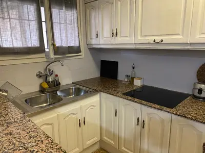 a kitchen with white cabinets and a sink at Apartamento entero con terraza en el centro de Rubí in Rubí