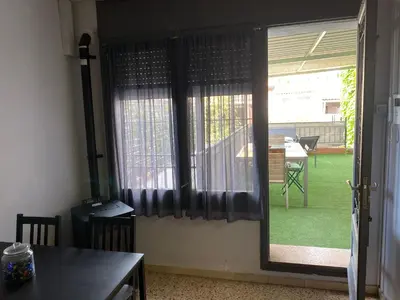a room with a window with a table and a patio at Apartamento entero con terraza en el centro de Rubí in Rubí