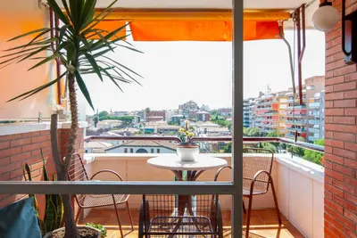 a balcony with a table and a view of a city at Apartment near the beach and Port Marina of Premia in Premiá de Mar