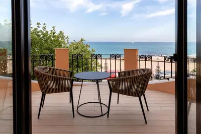 a table and chairs on a balcony with a view of the ocean at AB BOUTIQUE HOTEL - Adults only in Sant Vicenç de Montalt