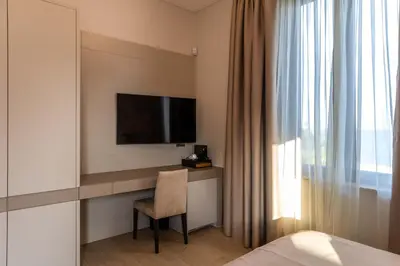 a bedroom with a desk with a television and a chair at AB BOUTIQUE HOTEL - Adults only in Sant Vicenç de Montalt