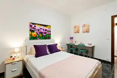 a bedroom with a bed with purple pillows and a table at Stay U-nique Apartments La Bordeta in Barcelona