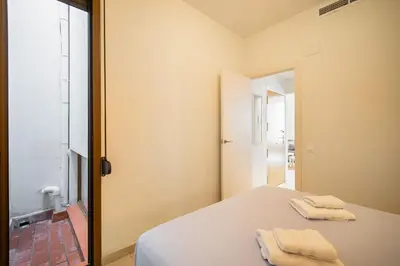 a bedroom with a bed with two towels on it at NICE CENTRIC APARTMENT in Vilanova i la Geltrú