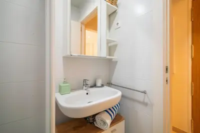 a white bathroom with a sink and a mirror at NICE CENTRIC APARTMENT in Vilanova i la Geltrú
