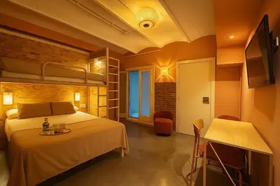 a bedroom with a bed and a table in a room at The Loft House Barcelona in Barcelona