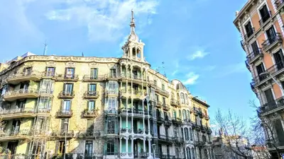 a large yellow building with a tower on top of it at BizFlats Eixample Apartments in Barcelona