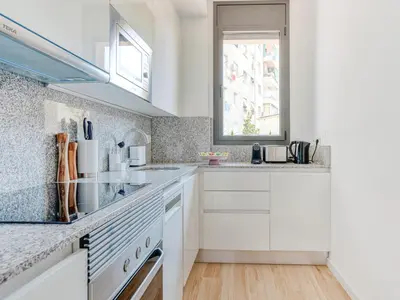 a kitchen with white cabinets and a window at Limehome Barcelona Carrer de Besalú 90 - estancia temporal in Barcelona