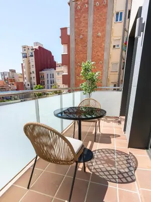 a patio with a table and chairs on a balcony at Limehome Barcelona Carrer de Besalú 82 in Barcelona