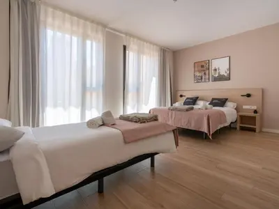 a bedroom with two beds and a large window at Limehome Barcelona Carrer de Besalú 82 in Barcelona